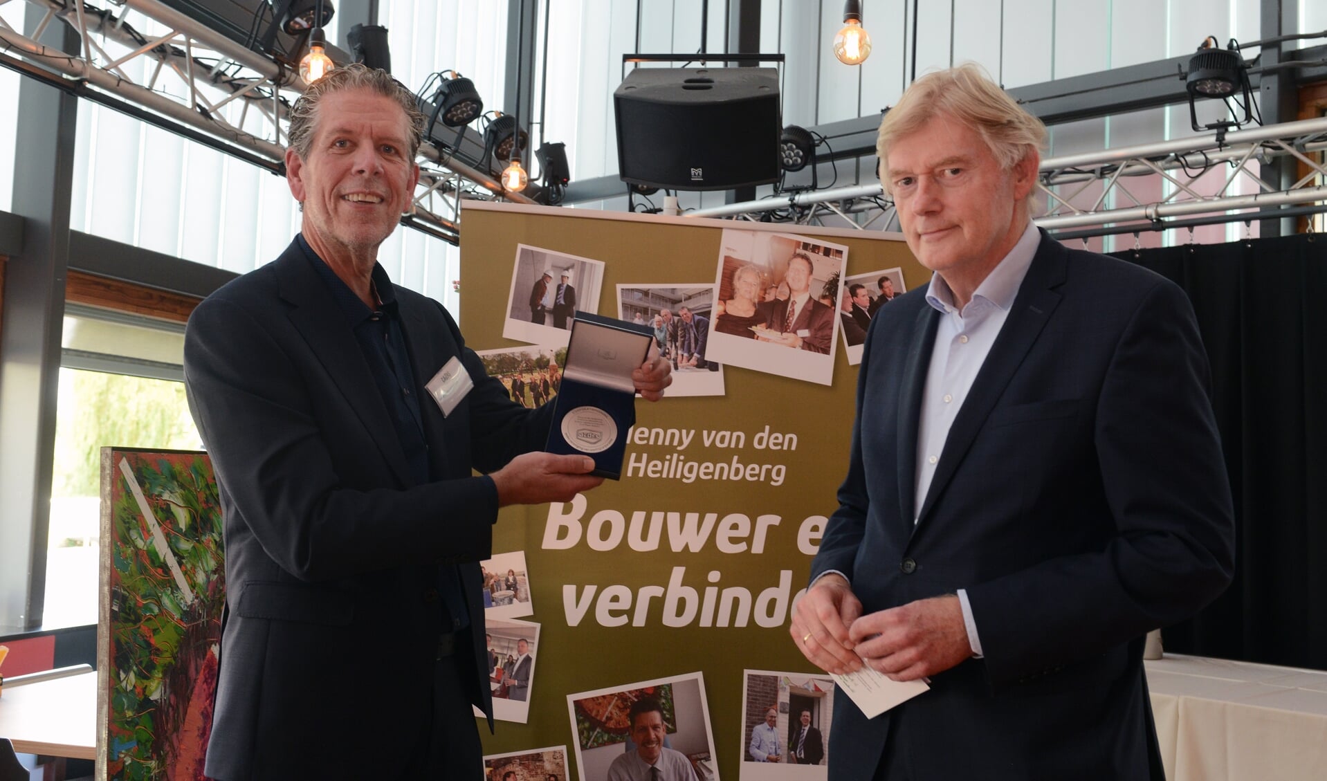 • Henny van den Heiligenberg (l) met Martin van Rijn bij het uitreiken van de penning. 