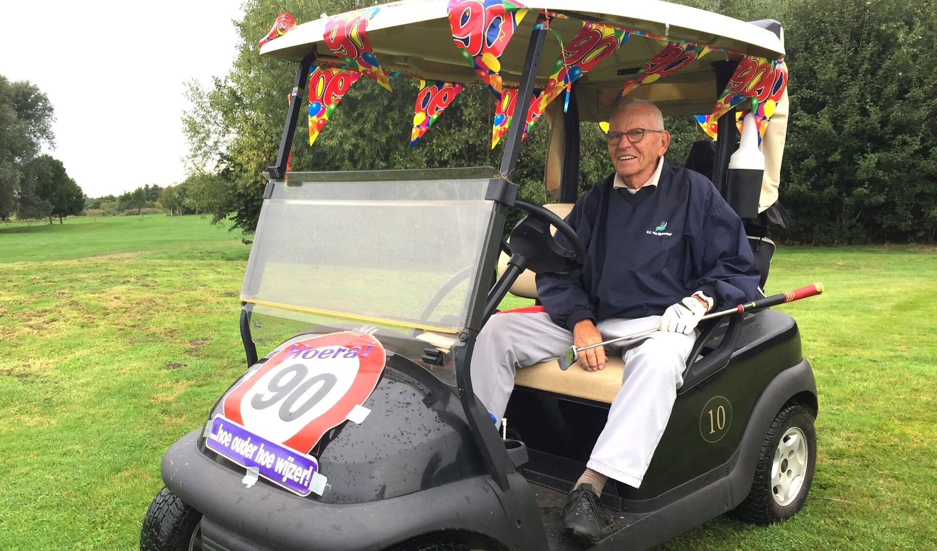 • Joop Heeck in de voor zijn verjaardag versierde golfkar.