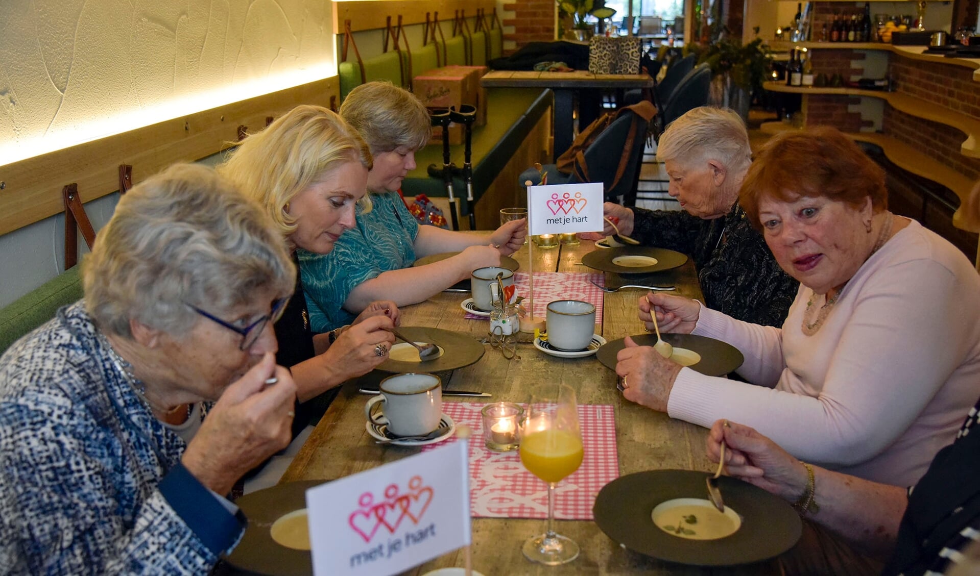 • Stichting Met Je Hart had een lunch voor eenzame ouderen georganiseerd. Wethouder Mariëtte Pennarts (linksmidden) at mee en sprak met de deelnemers.