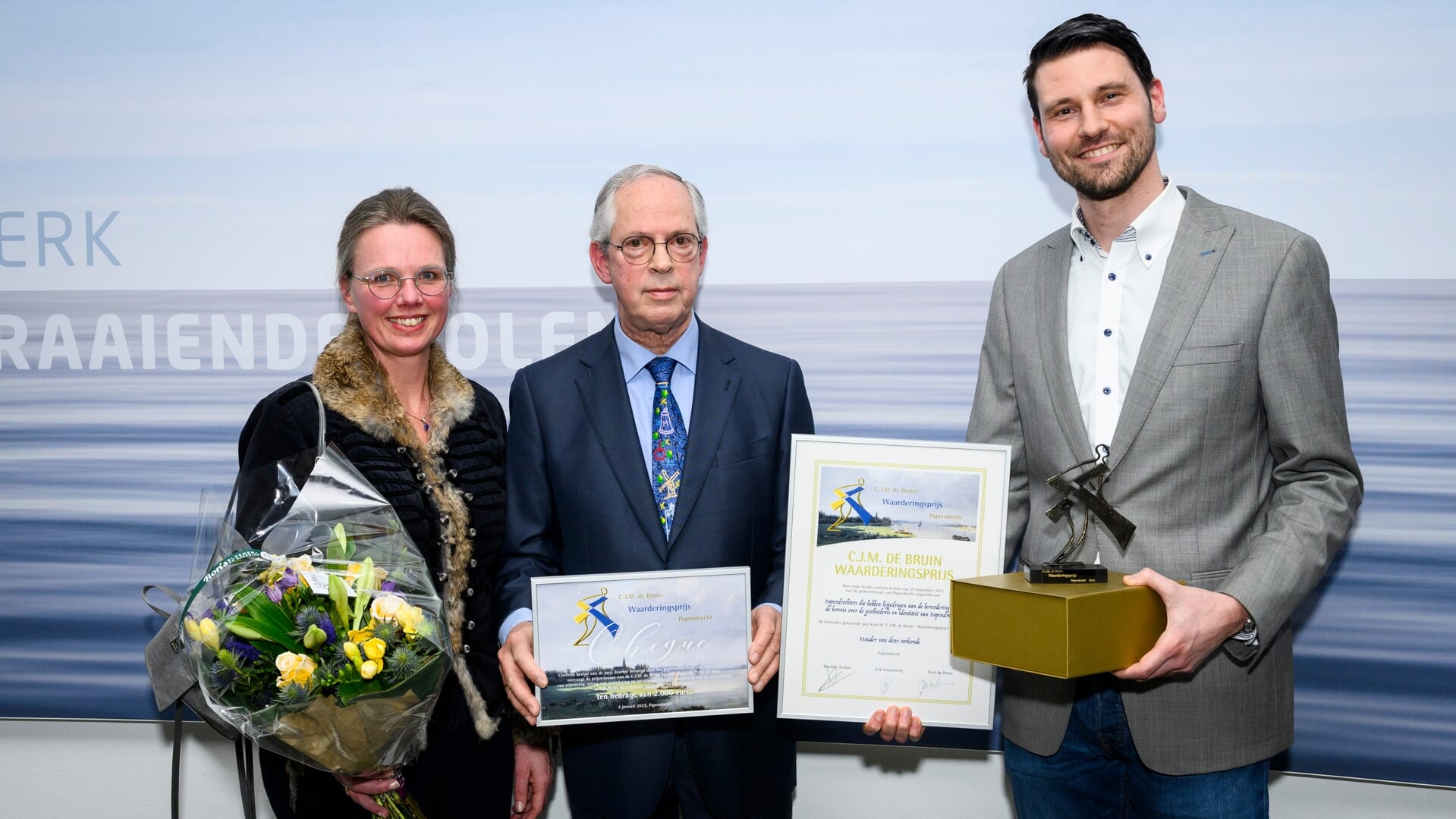 • De uitreiking van de prijs, met links voorzitter Rutger Tromp van Excelsior en oud-burgemeester De Bruin in het midden.