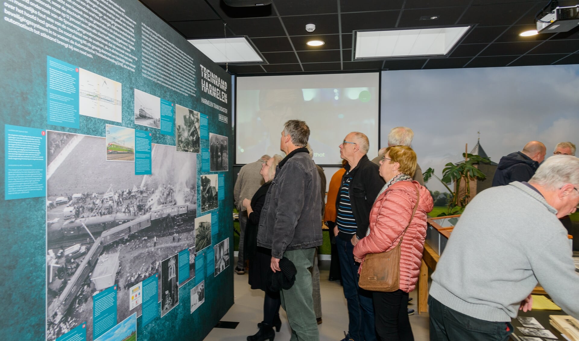 • Bezoekers in Dorpshuis Harmelen nemen een kijkje bij de expositie over de treinramp. 