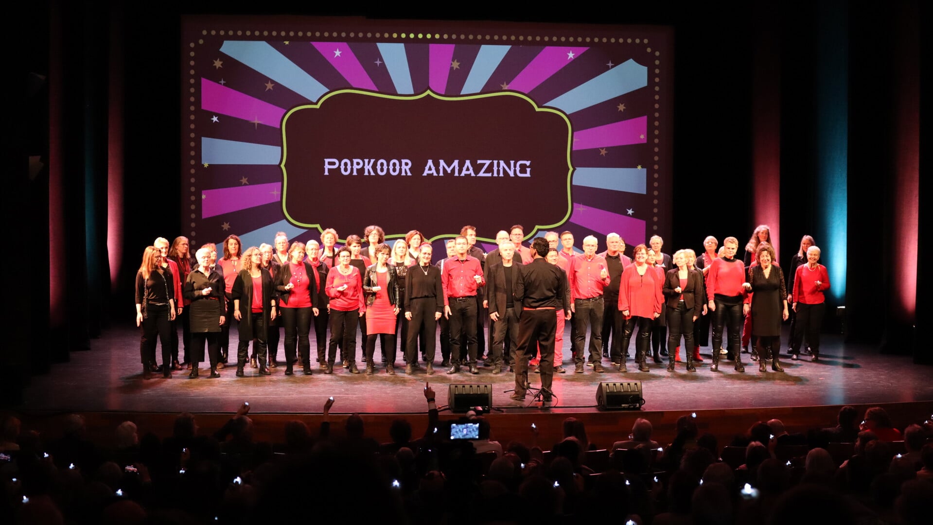 • Popkoor Amazing op het podium in theater DE KOM.
