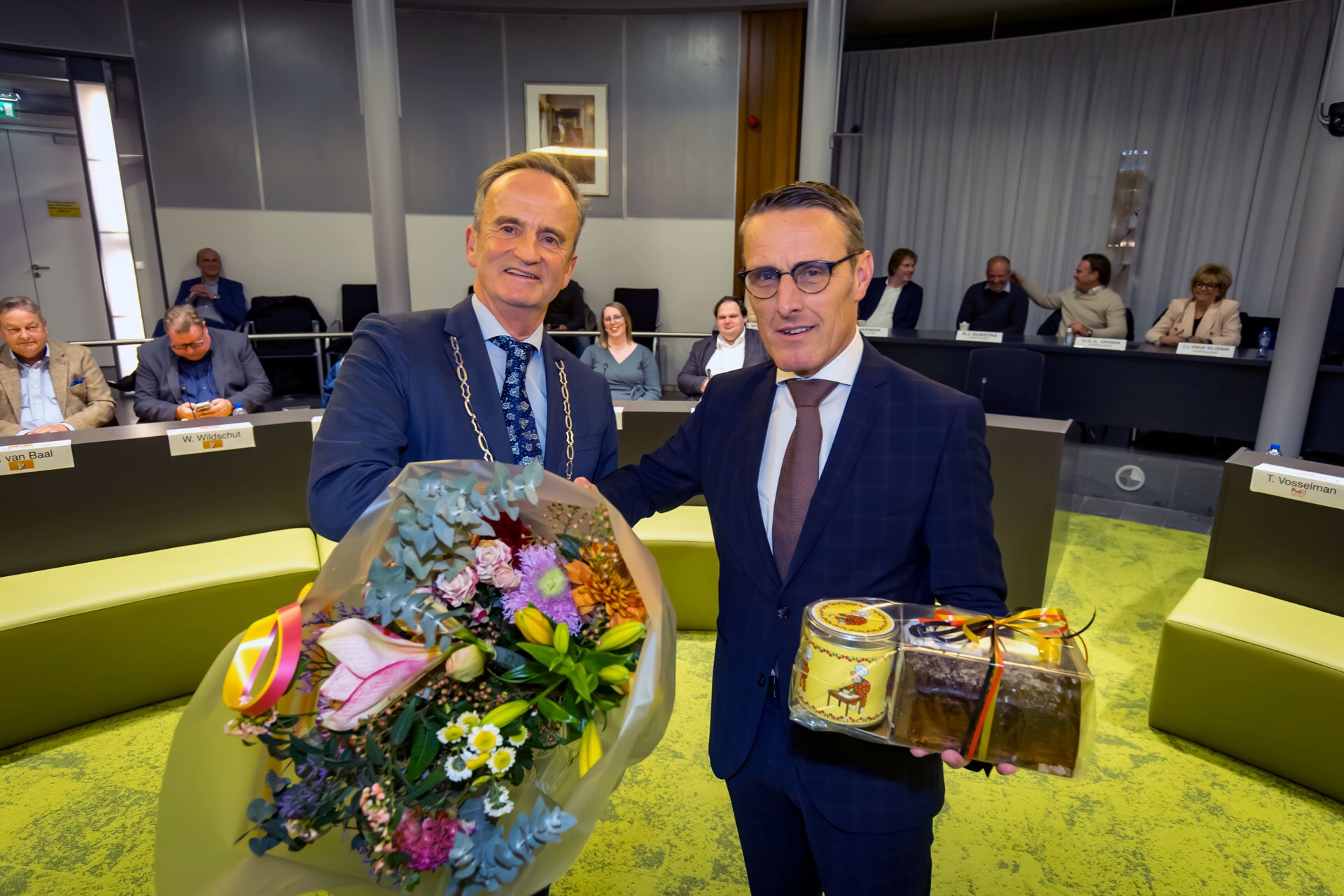 •  Loco burgemeester Tom van Oostrom (links) had voor Frank  van der Meijden bloemen en Tielse lekkernijen, waaronder een Kermiskoek. 