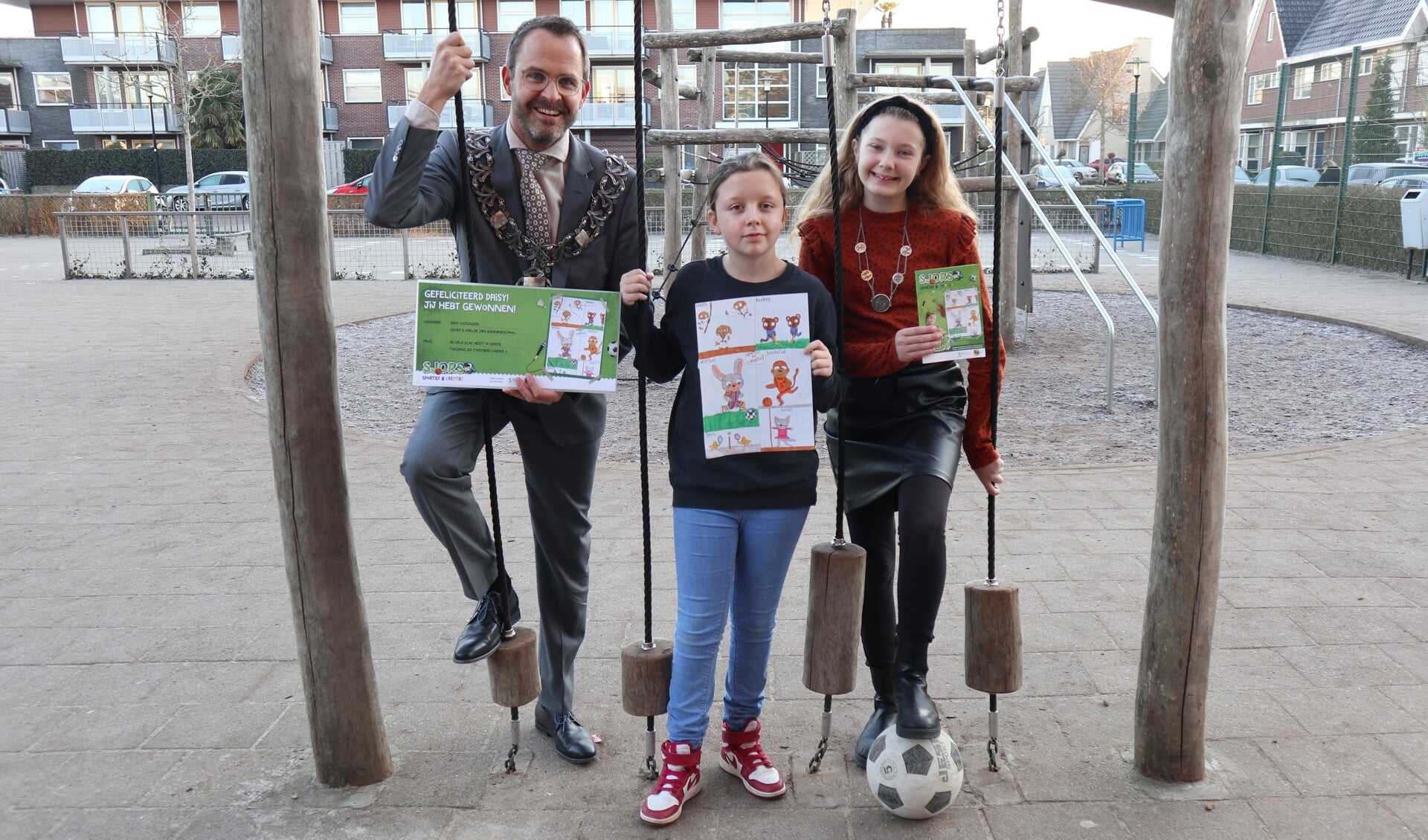 • Burgemeester Laurens de Graaf, winnares Daisy Cozijnsen en kinderburgemeester Iza van Dam met het eerste ‘Sjorsboekje’  