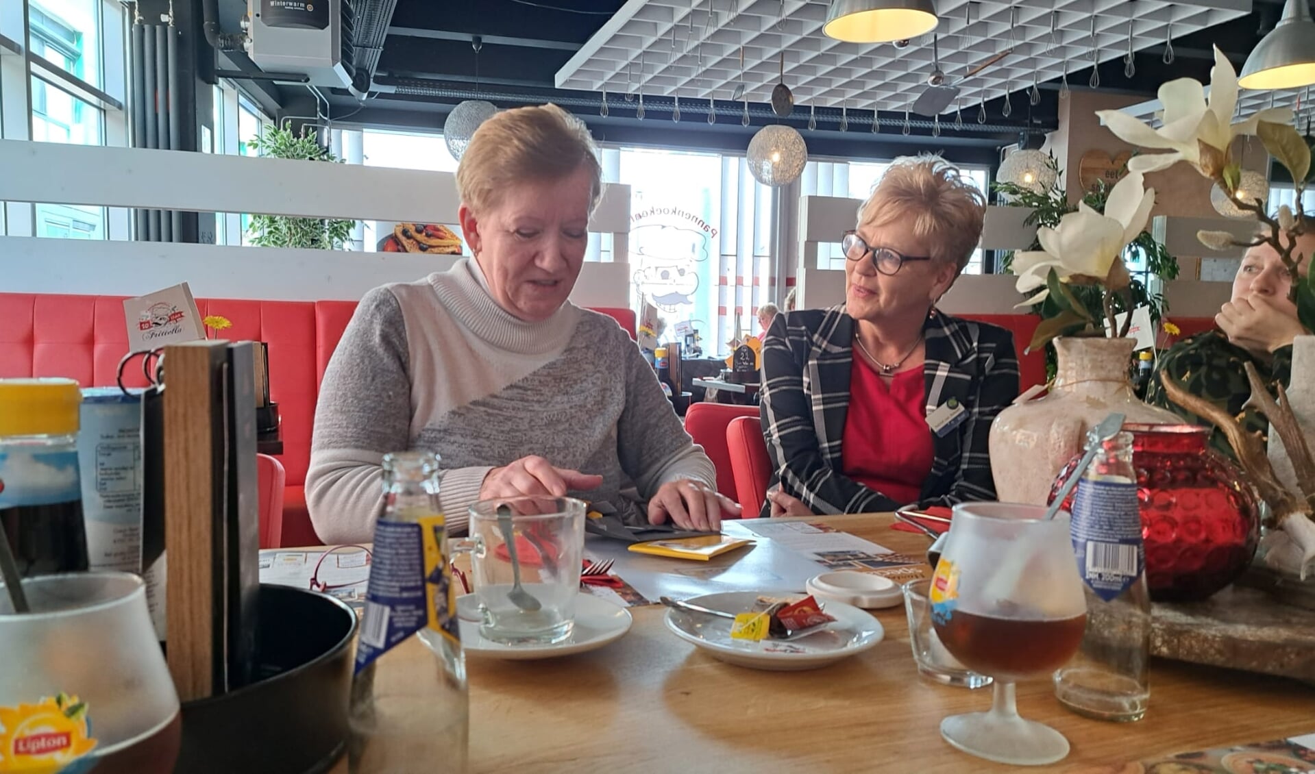 • Jubilaris Trudy Lobé (links) opent onder toeziend oog van teammanager Astrid van Rekom haar cadeau.