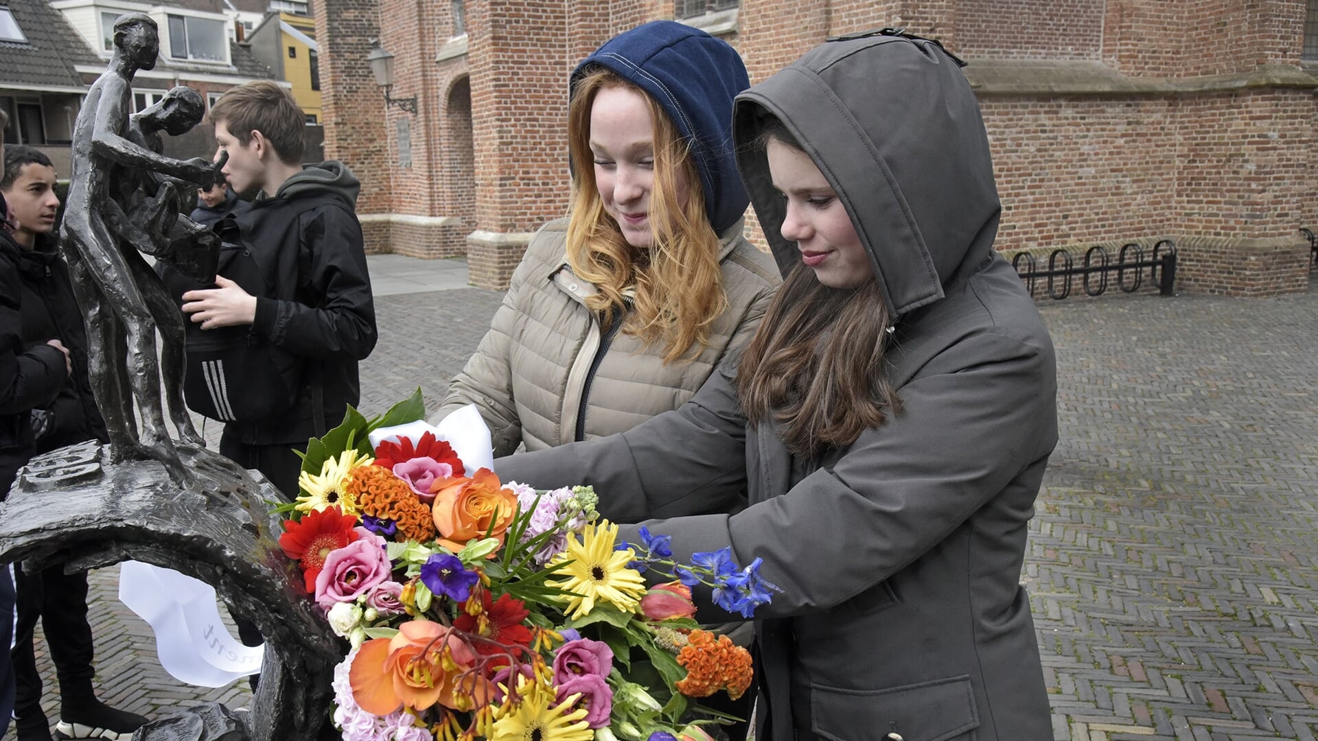 • Fay en Isa legden dinsdagmiddag op het Kerkplein in Woerden bloemen bij het door het Minkema College geadopteerde oorlogsmonument voor de gebroeders Jan en Gerrit Vergeer; 'Drukkers in Verzet'. 