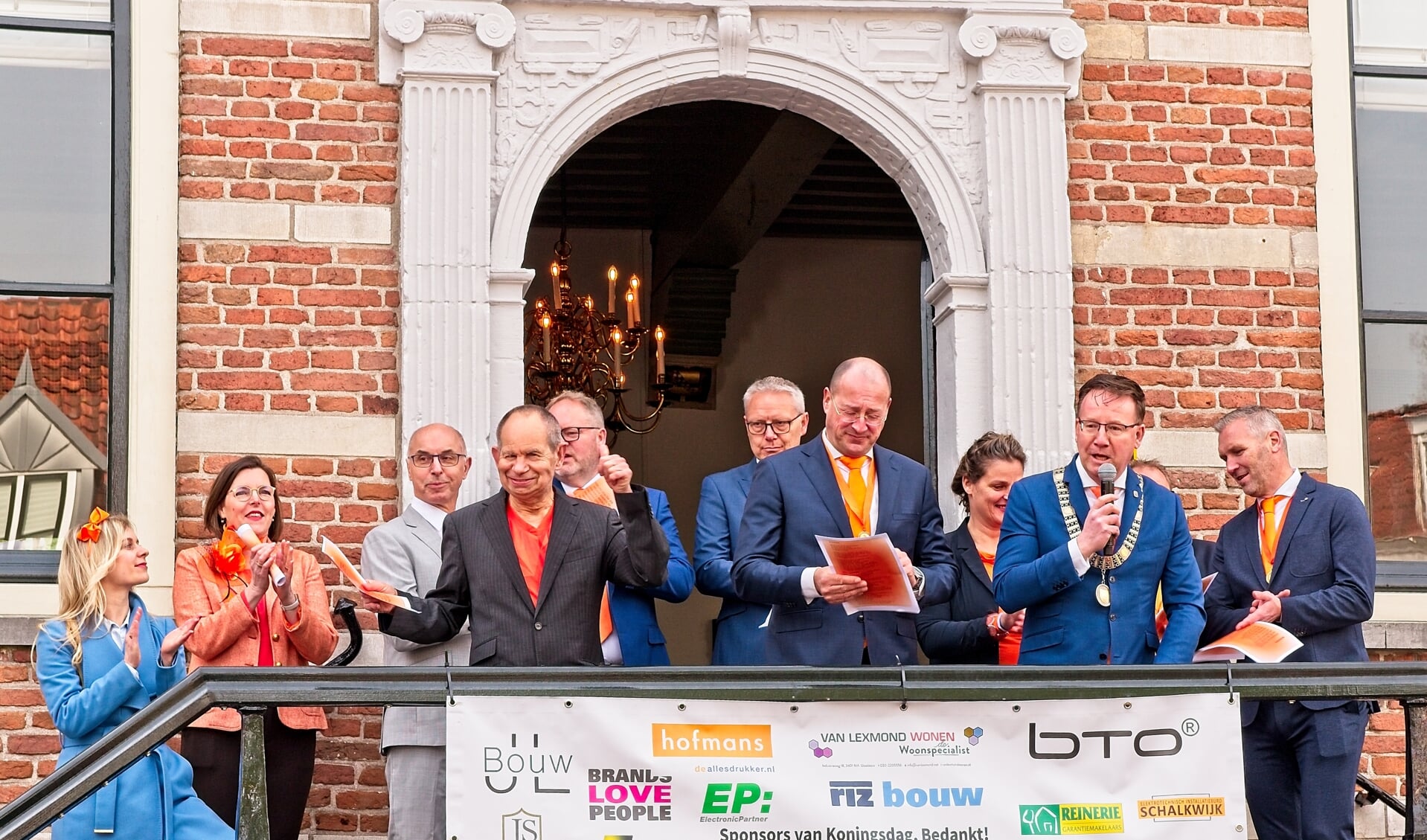 • Burgemeester Patrick van Domburg, leden van de Oranjevereniging en raadsleden op het bordes (met Kees Kortekaas)