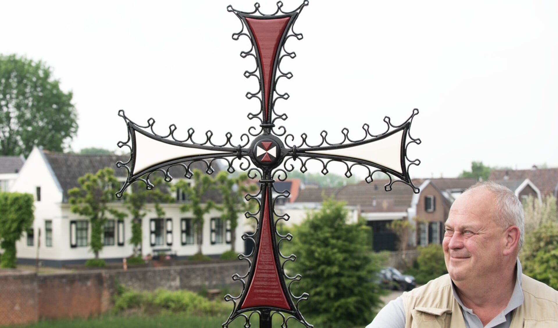 Vol trots toont Theo Witjes de nieuwe replica van het Kruisheren gevelkruis.