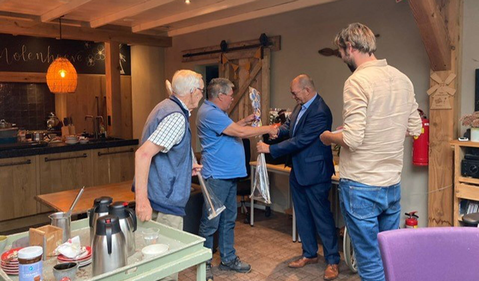 • Deelnemers van Zorgboerderij de Molenhoeve overhandigen een attentie aan de wethouder.