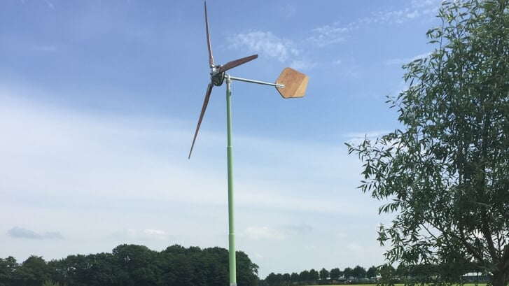• Een kleine windmolen met houten wieken op het Groningse platteland.