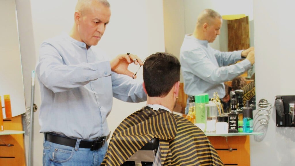 •  Barbier Noureddine Maatougui aan het werk in zijn barbershop M-Style.