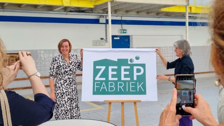• Wethouders Ellie Eggengoor (links) en Marieke Schouten onthullen het nieuwe logo van de Zeepfabriek.