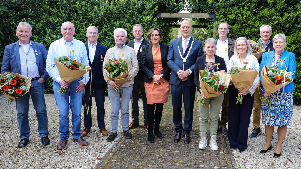 • De tien gedecoreerden uit de gemeente Molenlanden met in het midden burgemeester Theo Segers en zijn echtgenote.