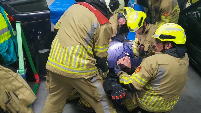 • Het team van de brandweerpost Nieuwegein tilt een slachtoffer uit een voertuig tijdens de oefening.