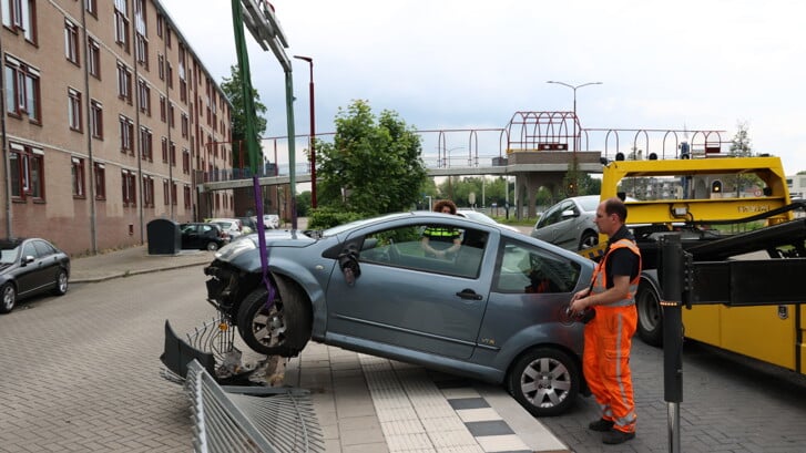 • Kraan takelt auto uit hek op de Zuiderstedeweg.