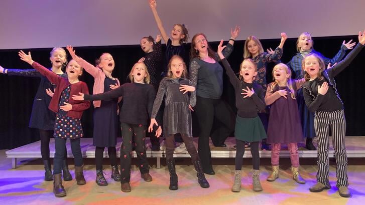 • Mimi Magusin samen met een aantal basisschoolleerlingen tijdens een concert. 
