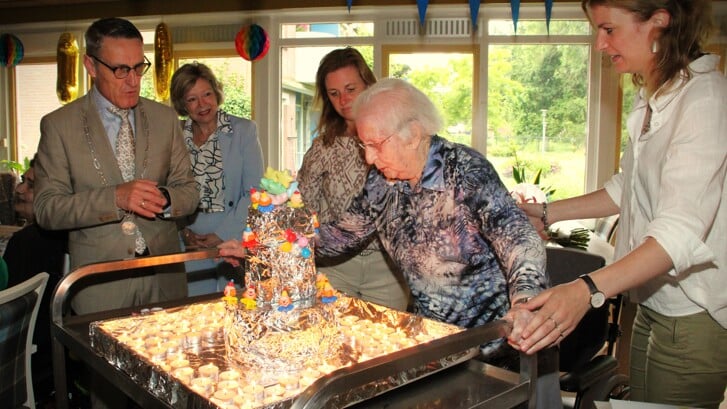 •  De 106-jarige  mevrouw Valkis-Stappershoef blaast de enorme hoeveelheid kaarsjes uit.