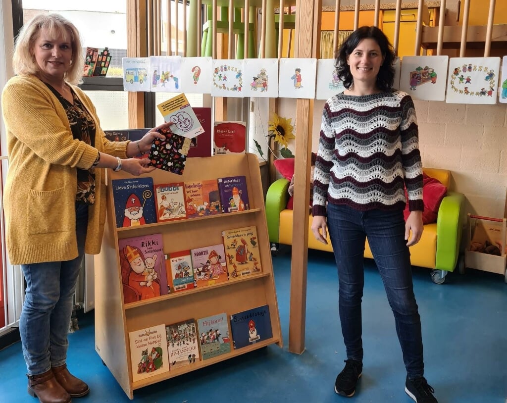 • Ellen van Eijmeren (Bibliotheek AanZet) en Leny de Bruin (Wasko Kinderopvang) met het keurmerk Boekstart bij de nieuwe boekenkast waarbij de boekjes goed zichtbaar en op ooghoogte staan. 