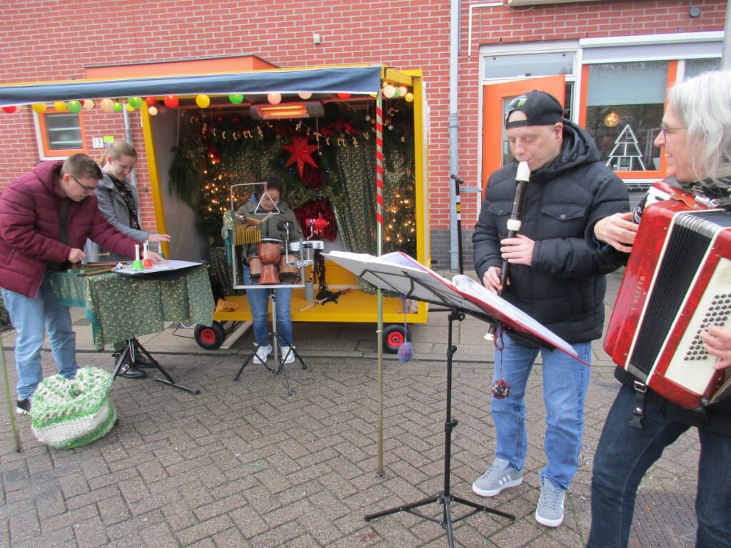 • Marian Verdonk op accordeon (r) begeleidt cliënten van de Lingebolder bij de muziekkar in Kerstsfeer.