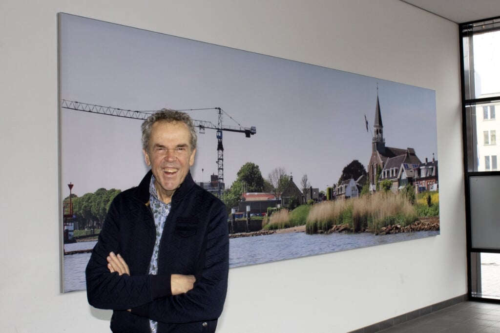 Fotograaf Wim Schut bij zijn fotowand in het woongebouw aan de Markt.