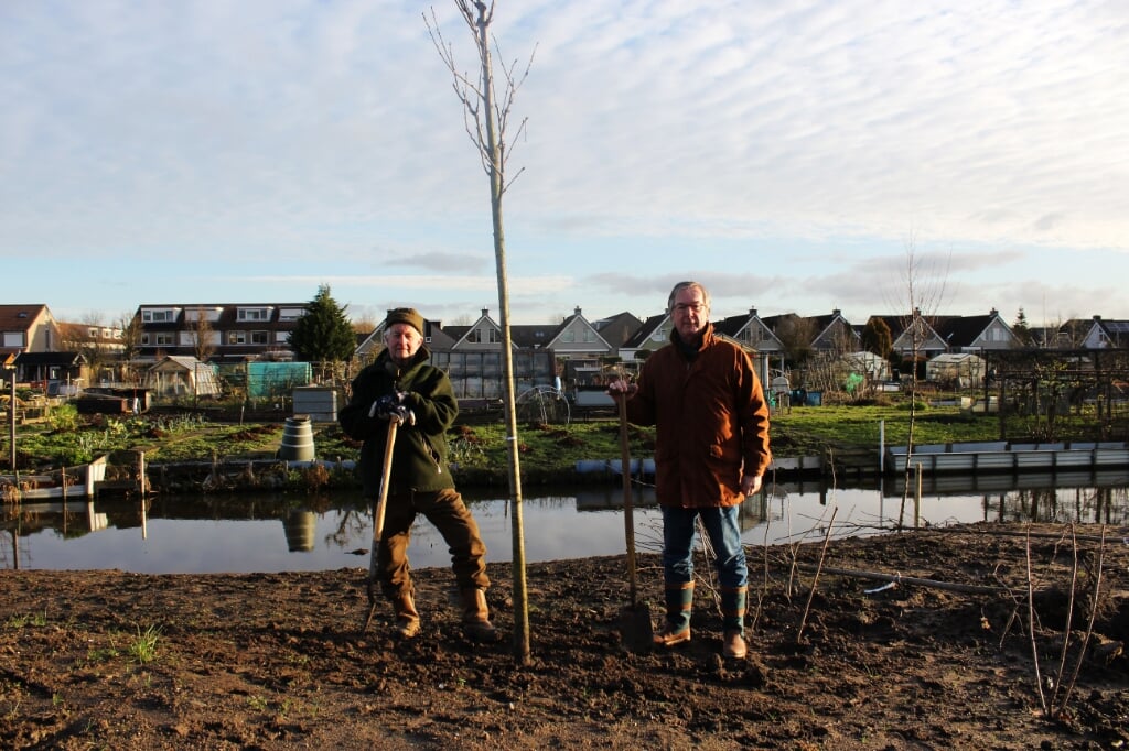 Aad den Boer (links) en Peter Janssen (rechts) planten namens de Lions bomen op 'het IJsvogeltje'.