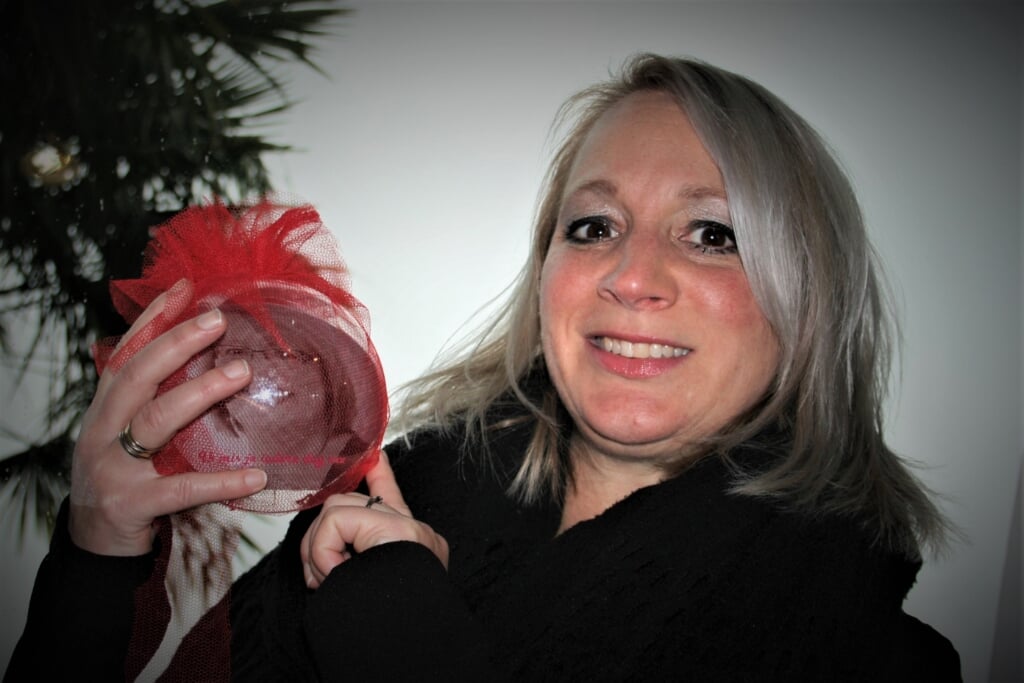 Sandra hangt zelf een kerstbal met een foto van haar overleden zus Anja in de boom.
