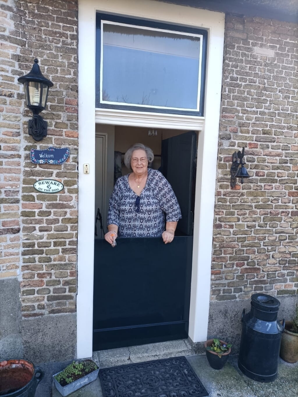 • Anneke van Driel in de deuropening van De Kerkbuurt.