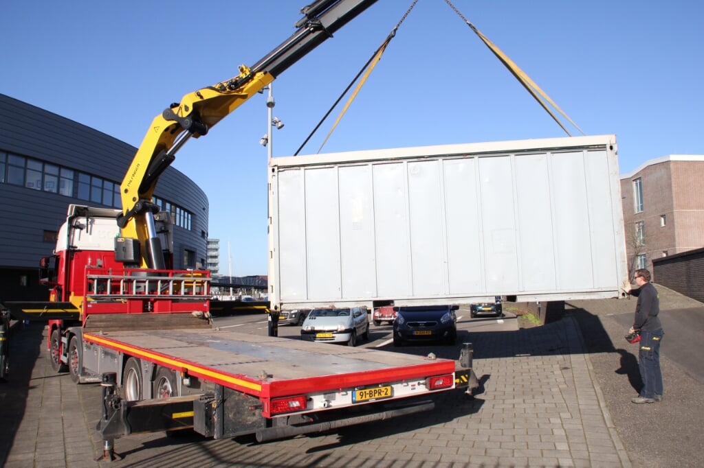 • Eén van de containers wordt op een vrachtwagen van Maat Transport geladen.