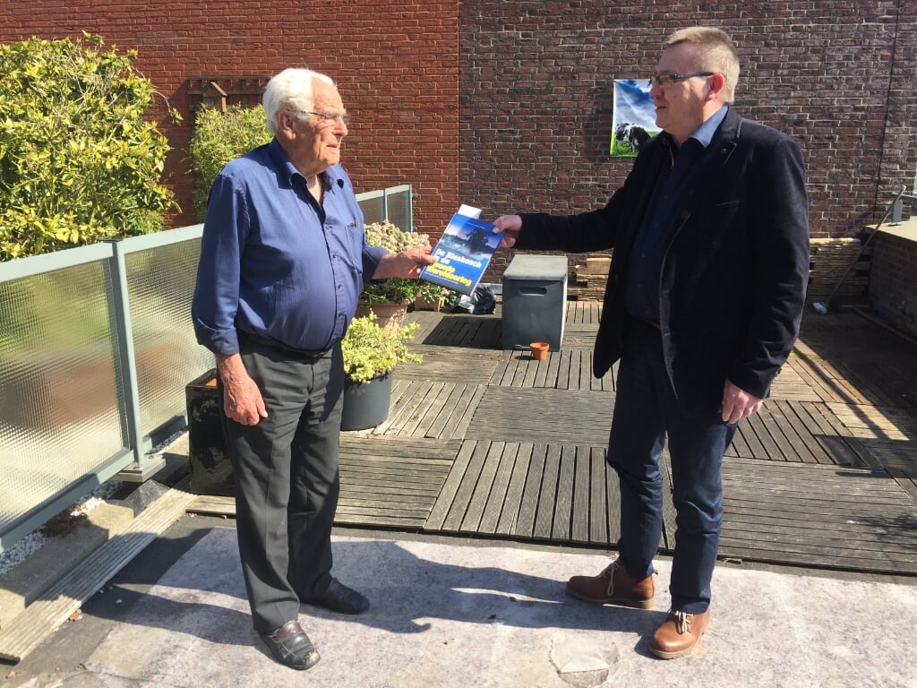• Alfons van Bokhorst overhandigt het eerste boek aan Fokko Spier.