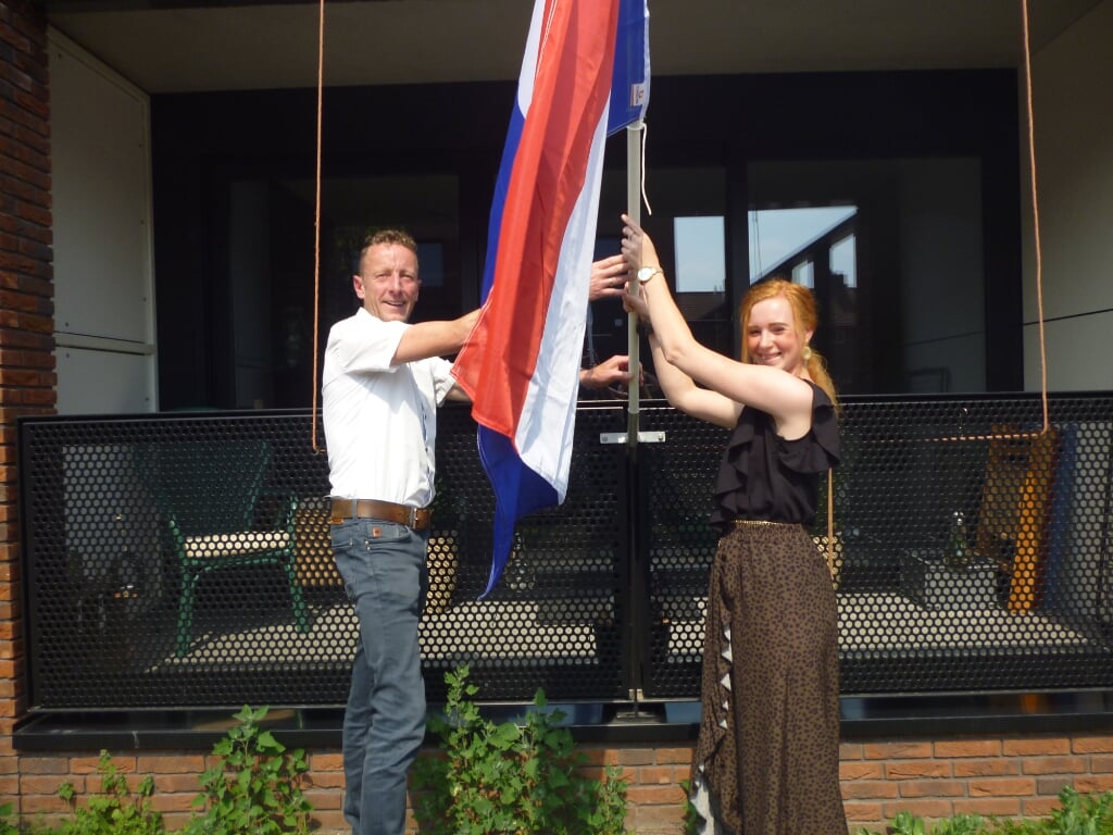 • Wethouder Bikker en huurder Lianne de Haan steken de vlag uit.