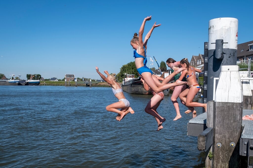 • Jeugd springt vanaf een steiger bij Ouderkerk de IJssel in. 