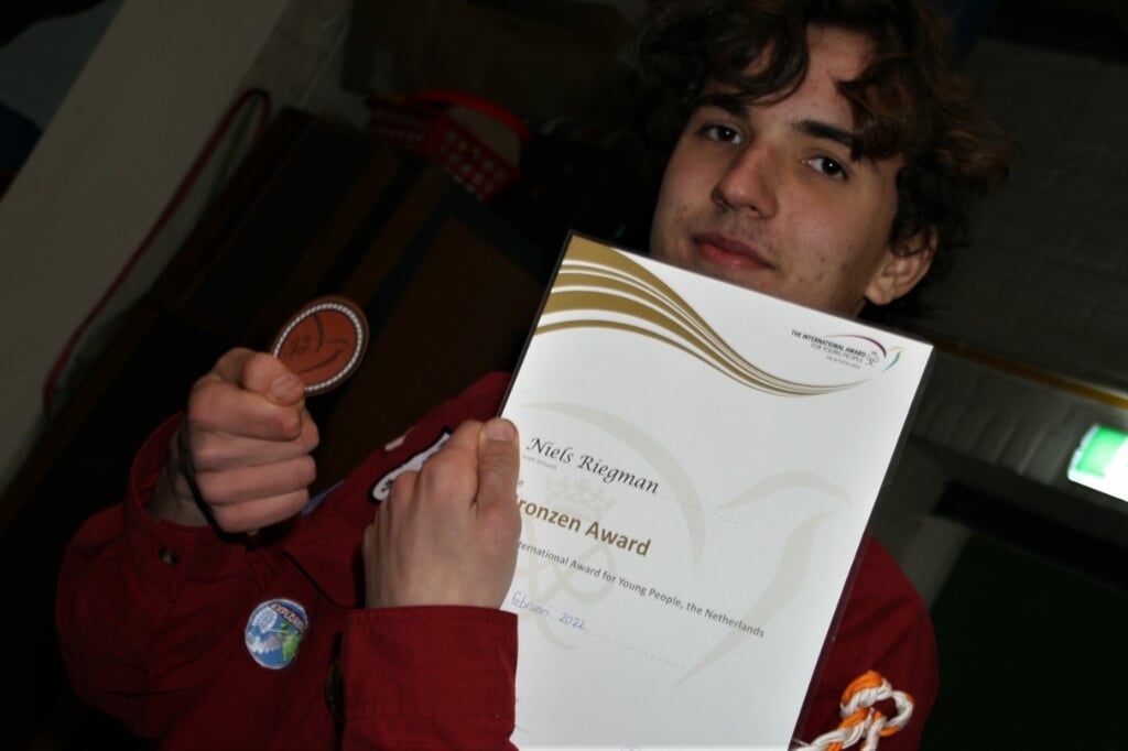 • Niels toont trots zijn Award, die hij zojuist van zijn Award-begeleider heeft gekregen.