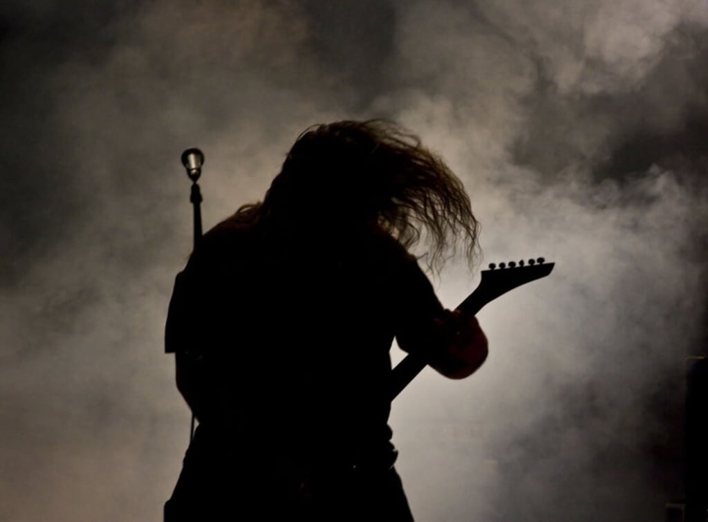 Silhouette of a guitar player live on stage