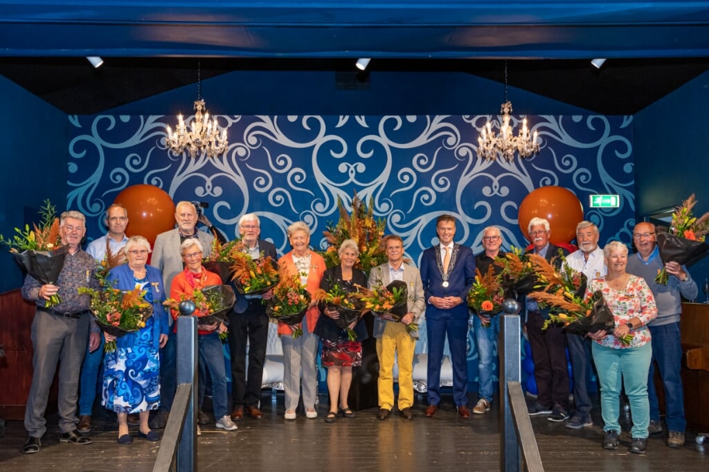 • Groepsfoto van de gedecoreerden met in hun midden burgemeester Pieter Paans.
