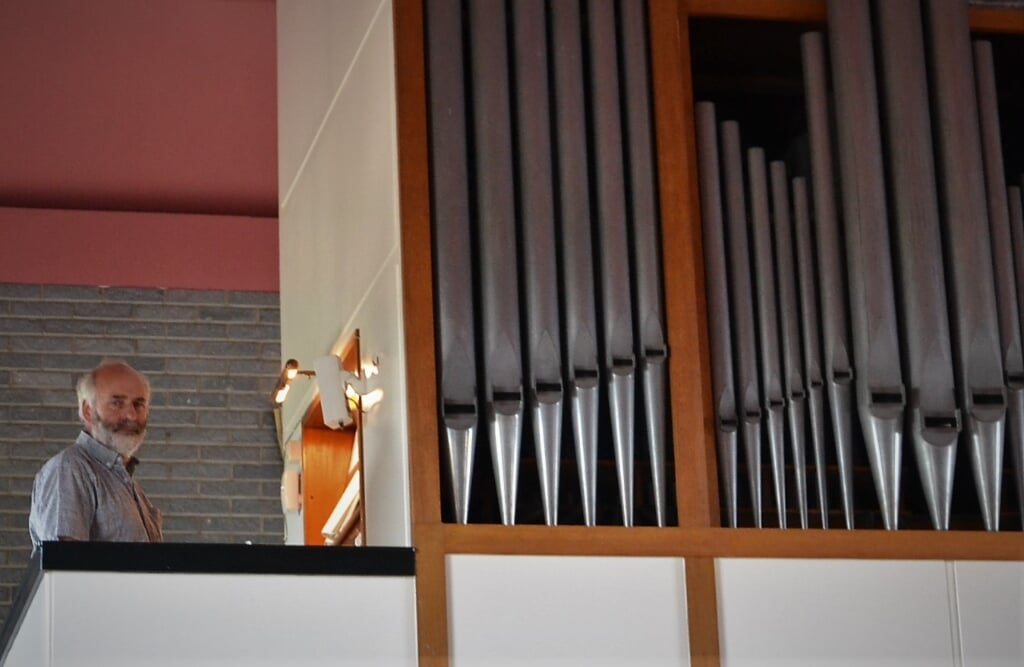 • Organist Johan de Leeuw achter het orgel. 