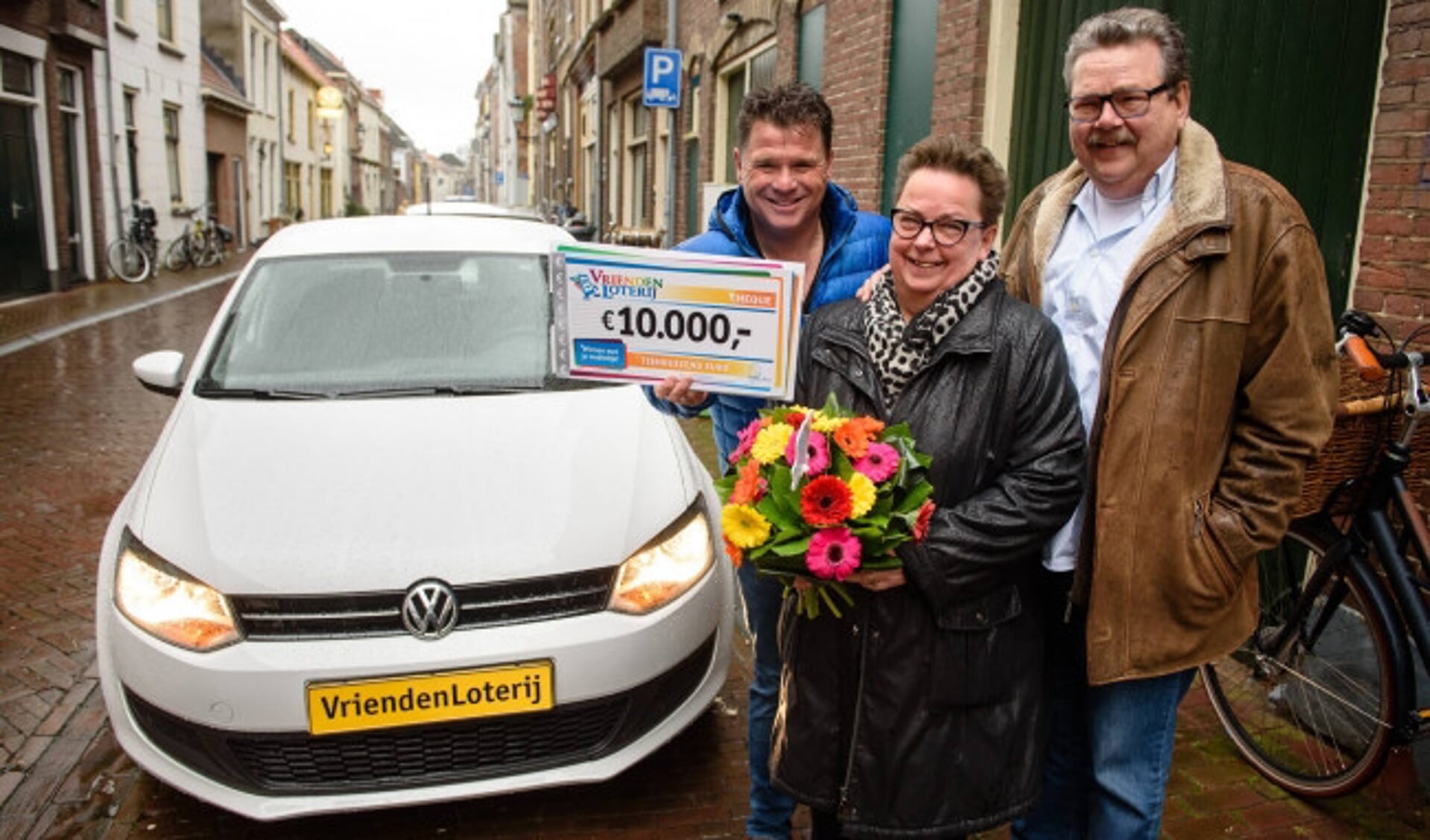  Jos van Ommen en echtgenoot Gert uit Kampen winnen 10.000 euro én een Volkswagen Polo bij de VriendenLoterij. Zij ontvangen de cheque en autosleutels uit handen van VriendenLoterij-ambassadeur Wolter Kroes.