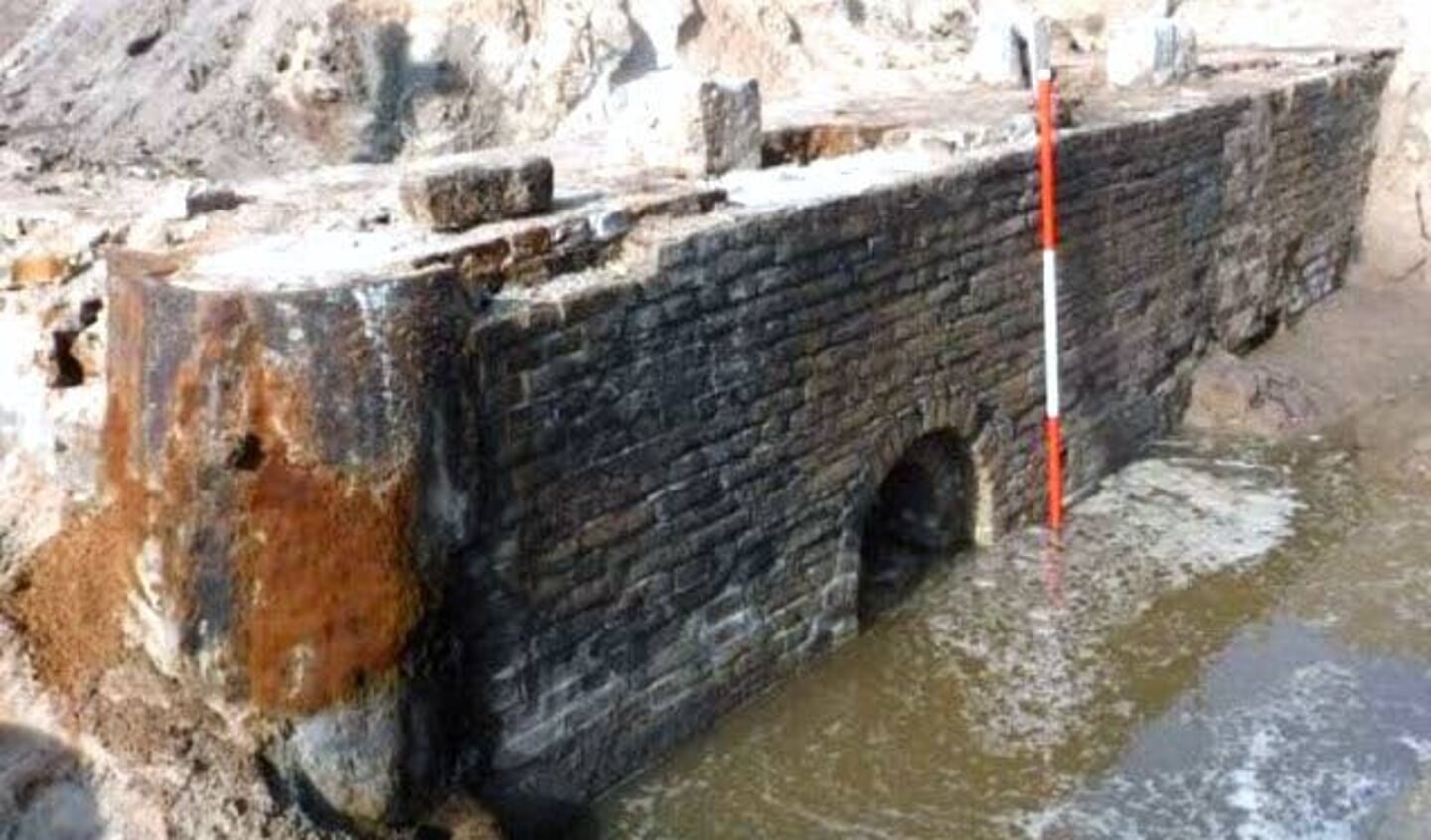 Westelijke muur met inlaatboog natuurstenen geleiders.