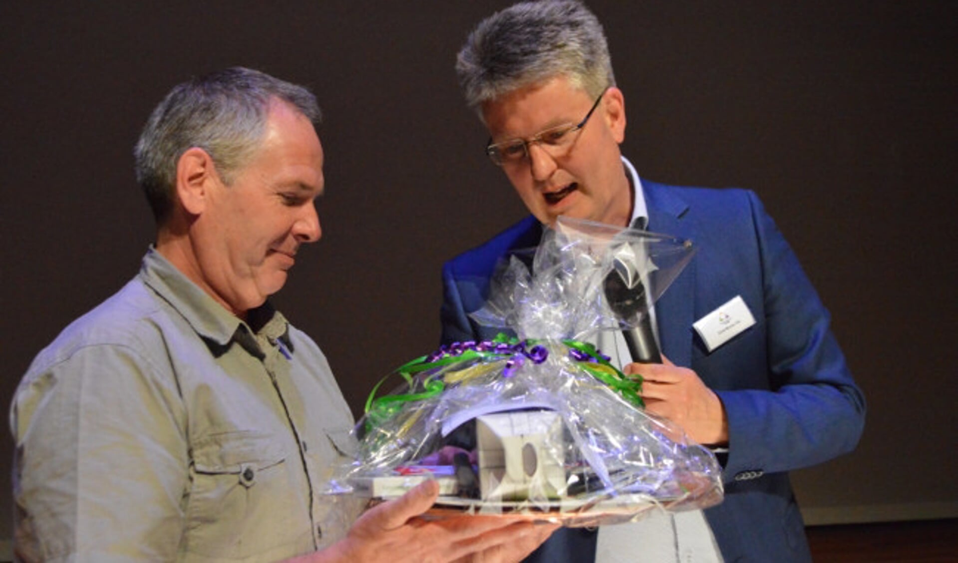  André van der Hulst (links) ontvangt het 'starterspakket' uit handen van wethouder Dirk Minne Vis.