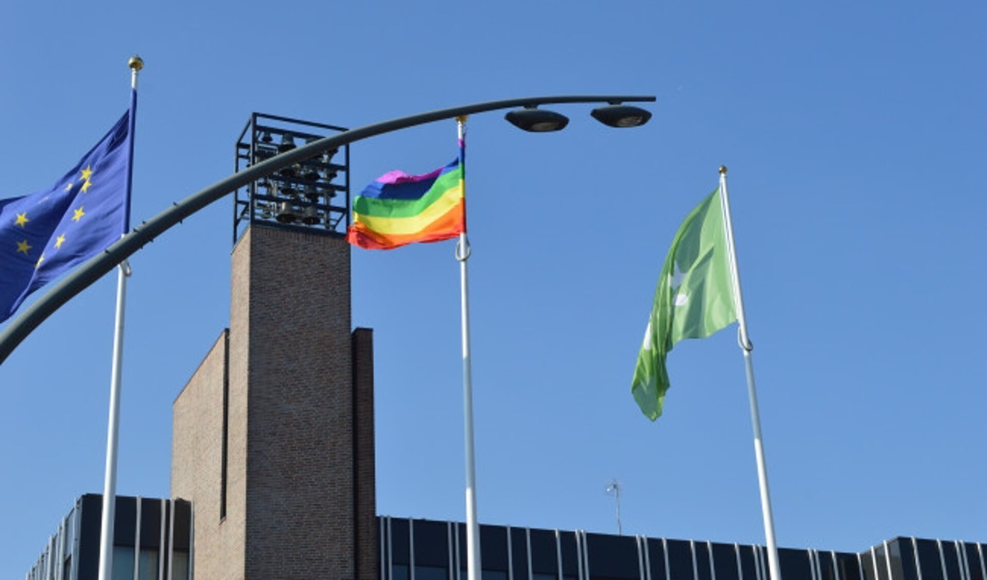  De regenboogvlag bij het gemeentehuis.