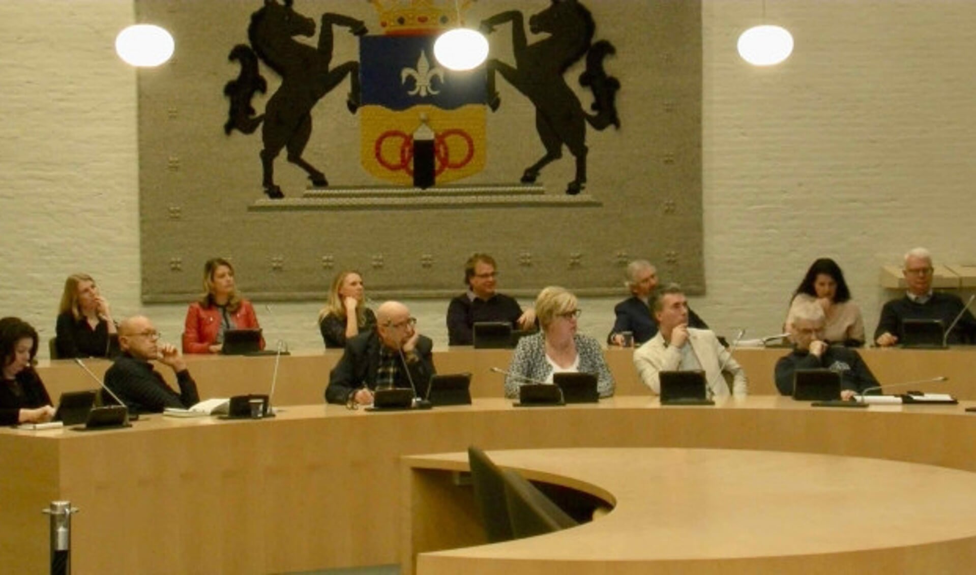  Raadsleden luisteren naar een uitleg over het gemeentehuis.