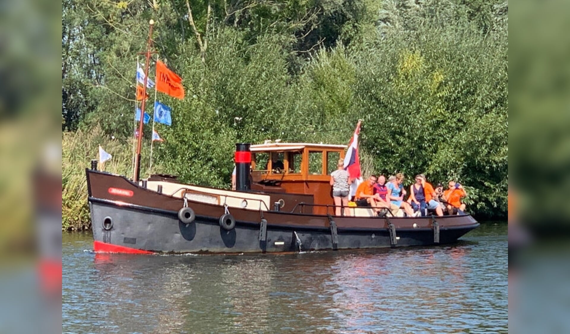  Jan Schuurhuis (zittend links met oranje shirt) tijdens de sleepbootdag.