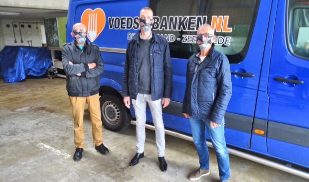 <p>Edwin Vrijenhoek, geflankeerd door bestuursleden van 'De Kostmand'</p>