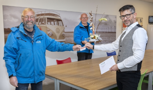 Voorzitter Albert Bleijenberg en secretaris Piet Bleeker overhandigen de eerste pas aan sponsor Remko Bosma van Wouda Installatietechniek.