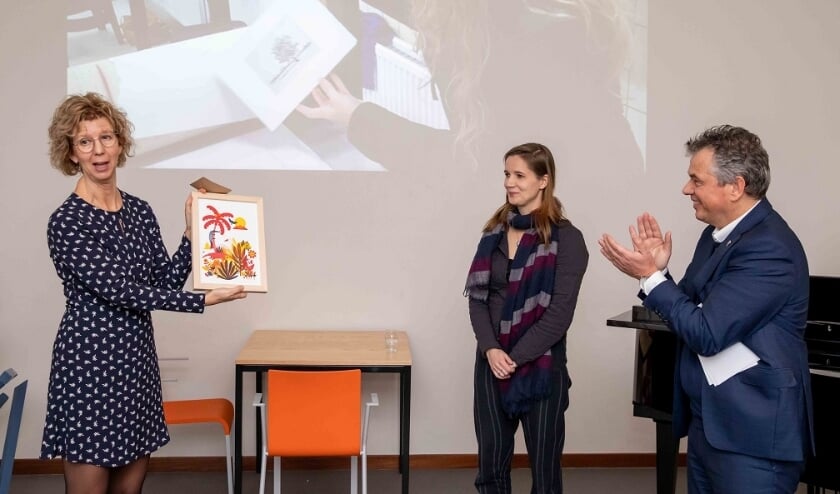 Wethouder Irma van der Sloot ontvangt een unieke kleurenzeefdruk uit handen van kunstenares/docent Kirsten Offringa en Quintusdirecteur Hendrik Jan Houtsma. 
