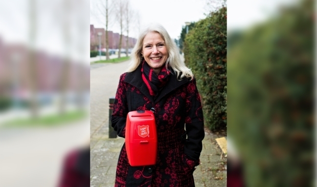 Een collectant met de bekende rode collectebus.