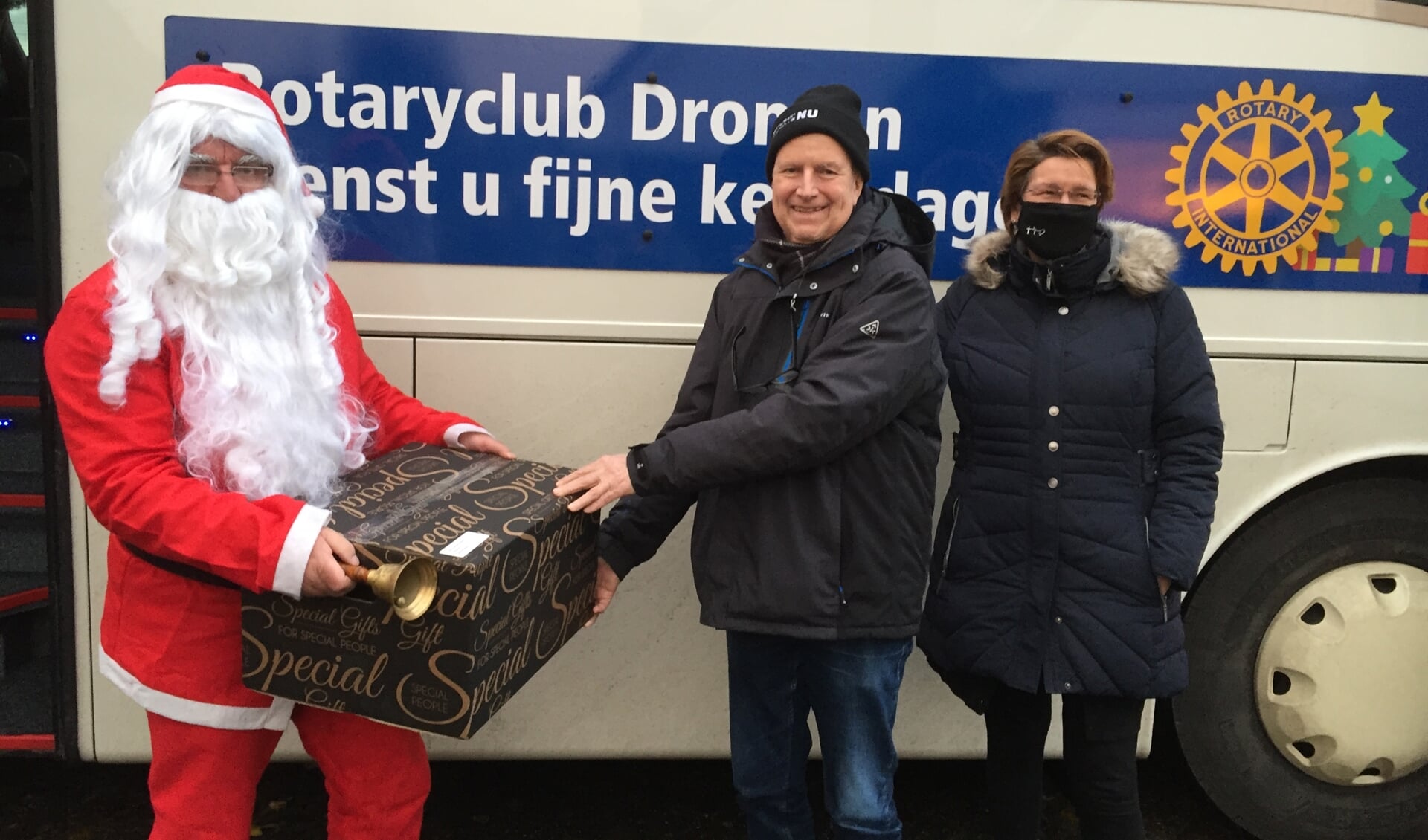 De kerstman overhandigt een kerstpakket namens Rotaryclub Dronten.