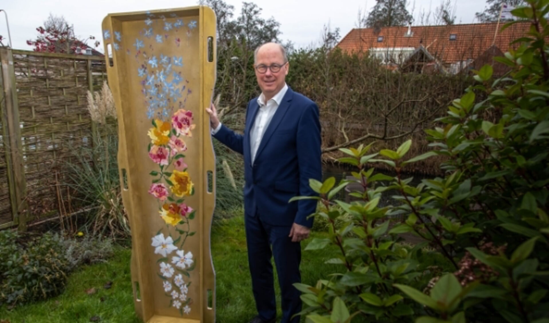 Ronald Visser met de fraai beschilderde draagbaar in zijn tuin. (Foto: Frans Paalman)