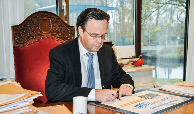 <p>Burgemeester Eddy Bilder zet zijn handtekening voor het eerste lidmaatschap van de uitgebreide versie van De Stadskoerier.</p>