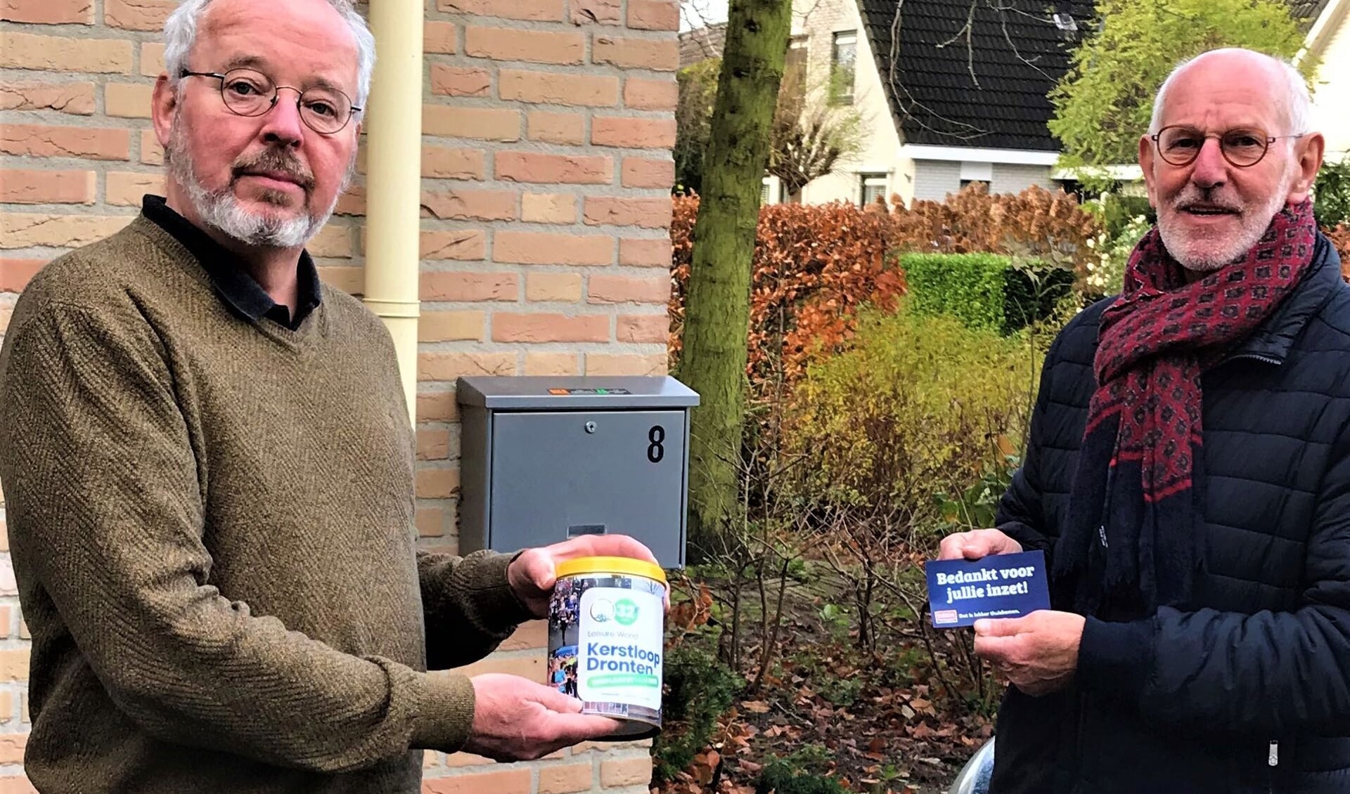 Vrijwilliger Johan Banis ontvangt de koeken uit handen van voorzitter Allert Everts.