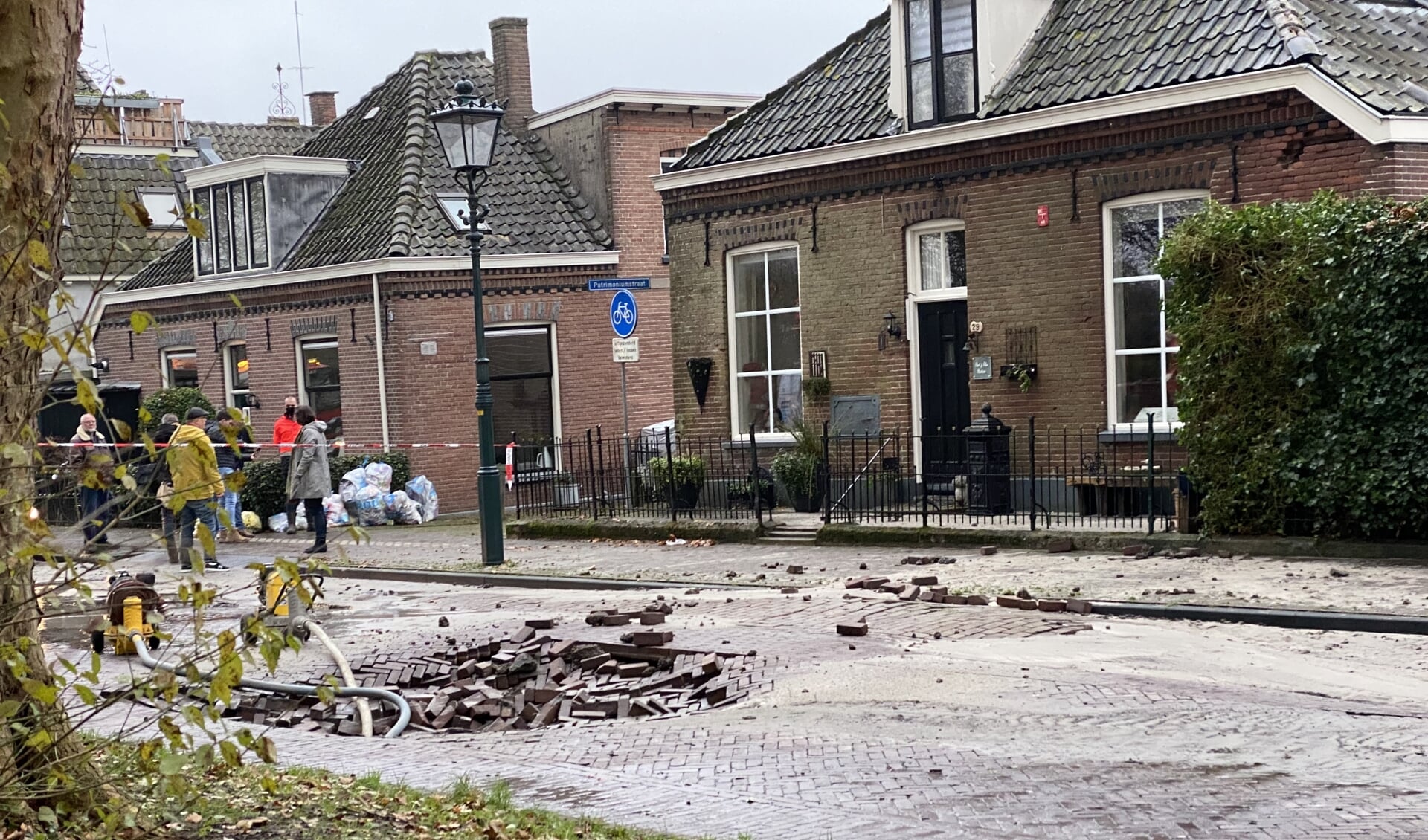 De gesprongen leiding heeft een flink gat in de weg achtergelaten.